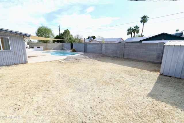 view of yard with a fenced in pool and a patio area