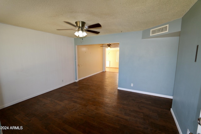 spare room featuring dark hardwood / wood-style flooring and a textured ceiling