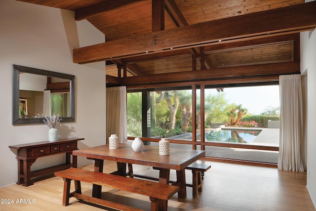 dining room with wood ceiling, lofted ceiling with beams, and light hardwood / wood-style flooring