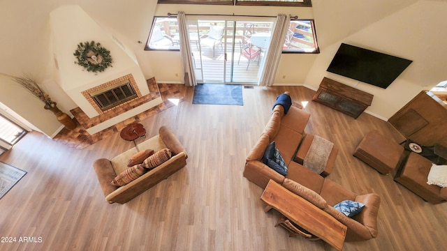 living room featuring a brick fireplace, heating unit, and light hardwood / wood-style floors