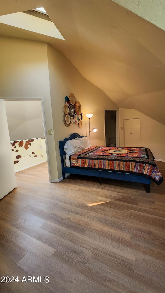 bedroom featuring lofted ceiling and hardwood / wood-style floors