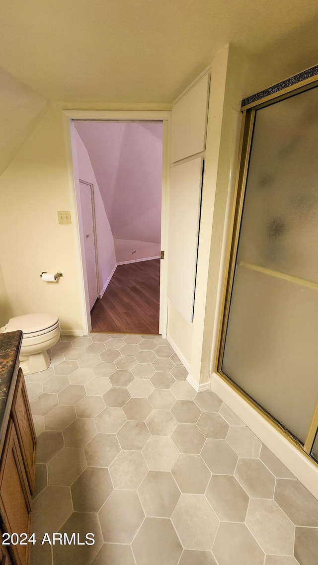 bathroom with vanity, toilet, an enclosed shower, and tile patterned flooring