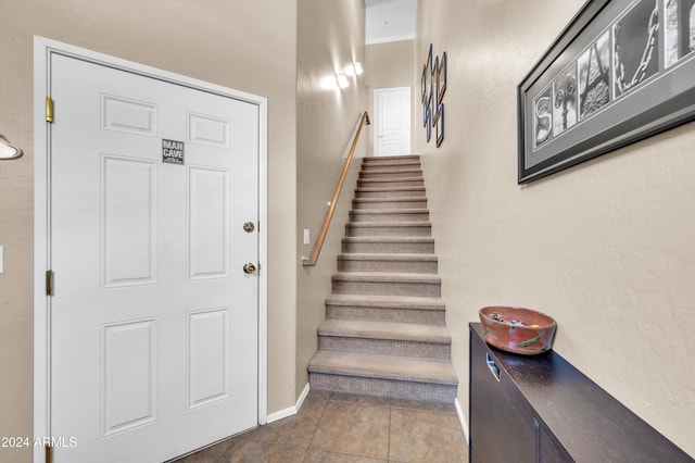 staircase featuring tile patterned flooring