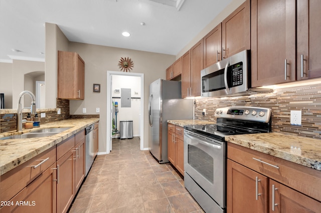 kitchen featuring light stone countertops, sink, stainless steel appliances, tasteful backsplash, and ornamental molding