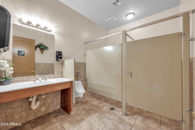 bathroom featuring tile patterned flooring, sink, and tile walls