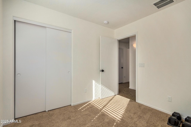 unfurnished bedroom featuring a closet and dark colored carpet