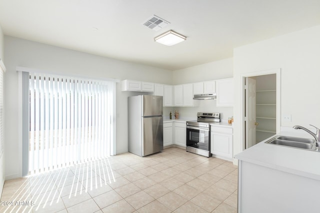 kitchen featuring white cabinetry, stainless steel appliances, light tile patterned flooring, and sink