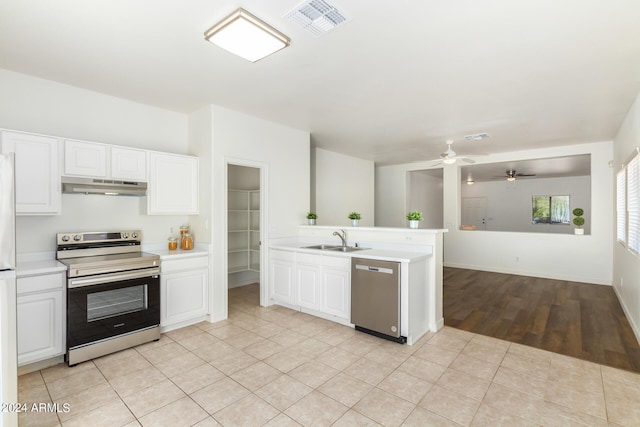 kitchen featuring light tile patterned flooring, sink, appliances with stainless steel finishes, kitchen peninsula, and white cabinets