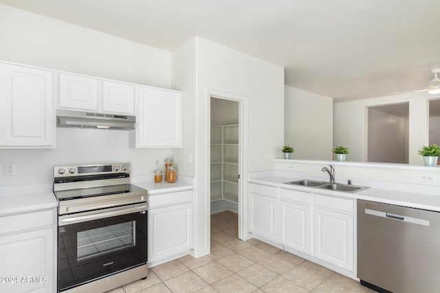 kitchen featuring sink, light tile patterned floors, ceiling fan, appliances with stainless steel finishes, and white cabinets