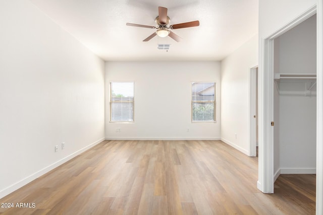 unfurnished bedroom with light hardwood / wood-style flooring, a closet, and ceiling fan