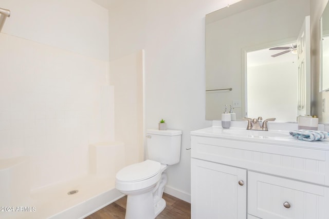 bathroom featuring toilet, a shower, vanity, hardwood / wood-style flooring, and ceiling fan