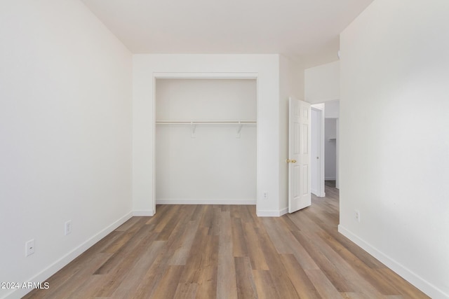 unfurnished bedroom featuring hardwood / wood-style flooring and a closet