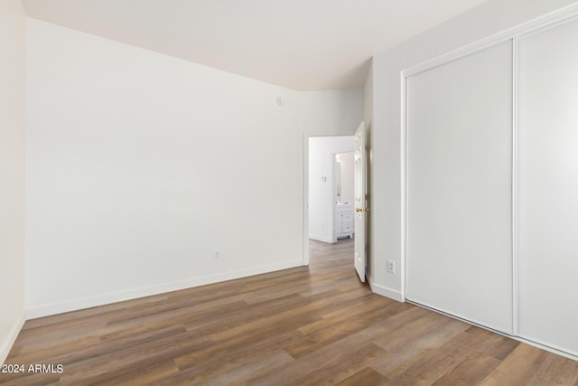 unfurnished bedroom featuring hardwood / wood-style floors and a closet