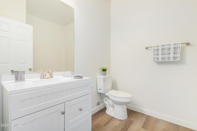 bathroom featuring wood-type flooring, toilet, and vanity