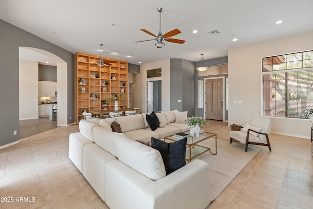 living room with light tile patterned floors, built in features, and ceiling fan