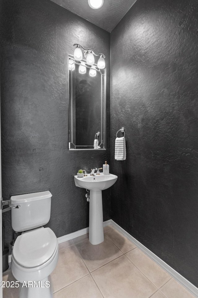 bathroom featuring a textured ceiling, tile patterned floors, and toilet