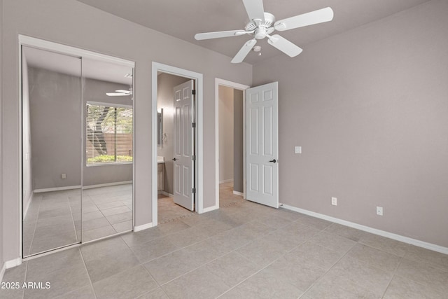 unfurnished bedroom with ceiling fan, a closet, ensuite bath, and light tile patterned floors