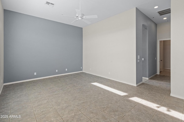 tiled spare room with ceiling fan