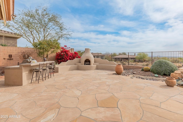 view of patio with an outdoor bar, an outdoor fireplace, and an outdoor kitchen