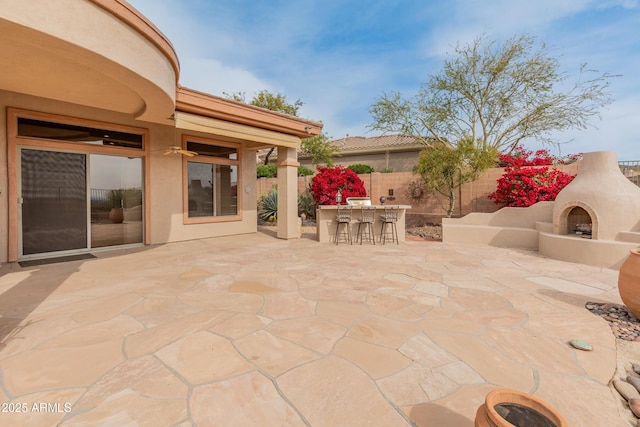 view of patio featuring a bar and exterior fireplace