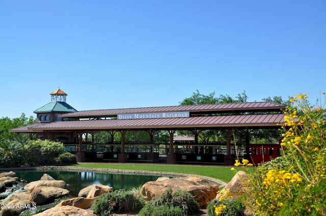 view of property's community featuring a gazebo, a lawn, and a water view