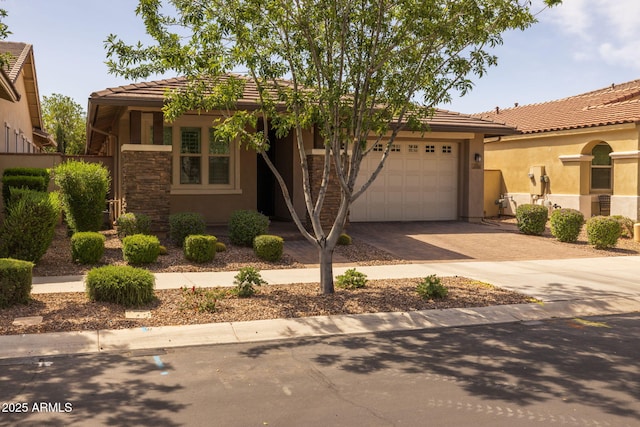 view of front of house with decorative driveway, an attached garage, a tile roof, and stucco siding