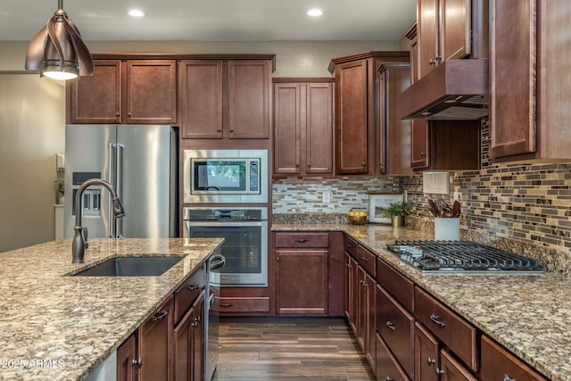 kitchen featuring dark wood-style flooring, appliances with stainless steel finishes, a sink, recessed lighting, and under cabinet range hood