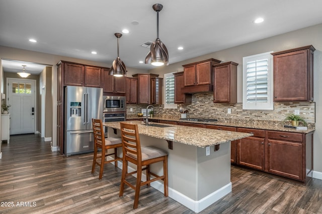 kitchen with a sink, tasteful backsplash, stainless steel appliances, and dark wood-type flooring
