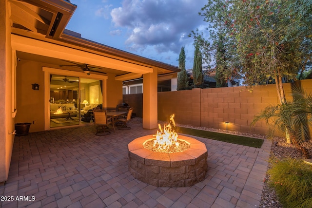 view of patio featuring outdoor dining area, a ceiling fan, an outdoor fire pit, and fence