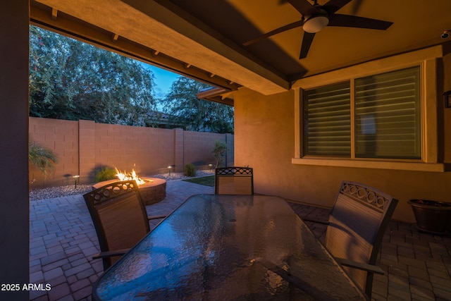 view of patio featuring fence, a ceiling fan, outdoor dining area, and an outdoor fire pit