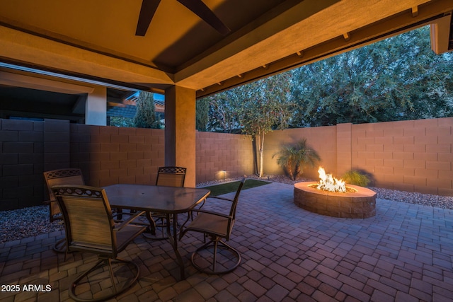 view of patio with a fenced backyard, outdoor dining space, and an outdoor fire pit
