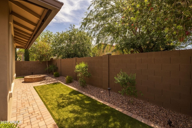 view of yard with a fenced backyard, a patio, and a fire pit