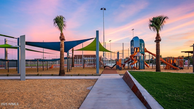 communal playground featuring a lawn and fence