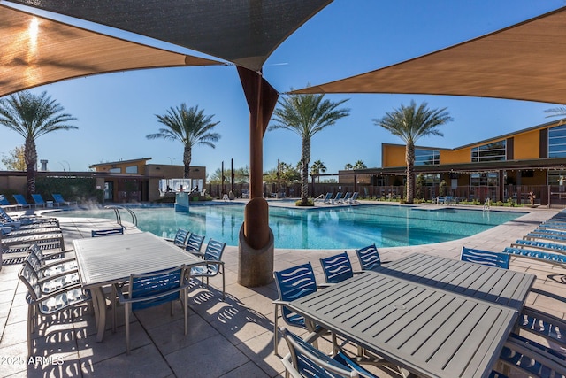 pool featuring fence, outdoor dining area, and a patio area