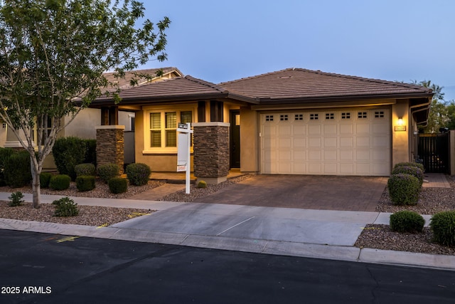 prairie-style house with a garage, stone siding, stucco siding, a tiled roof, and driveway