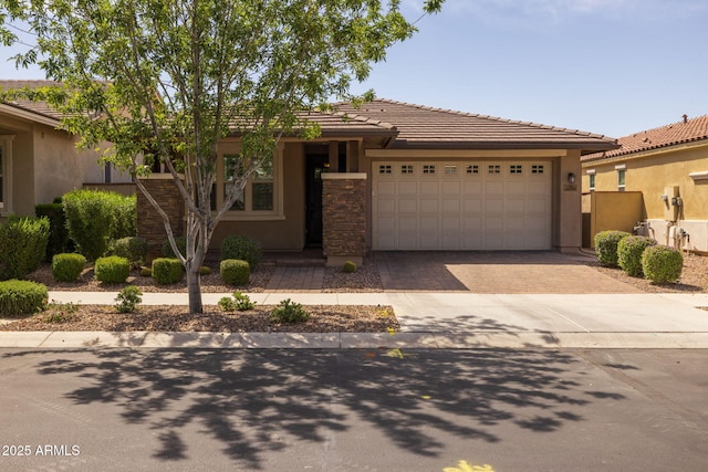single story home with a garage, stucco siding, a tile roof, and decorative driveway