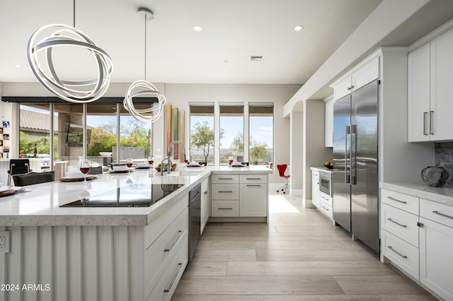 kitchen featuring white cabinets, pendant lighting, sink, and stainless steel appliances