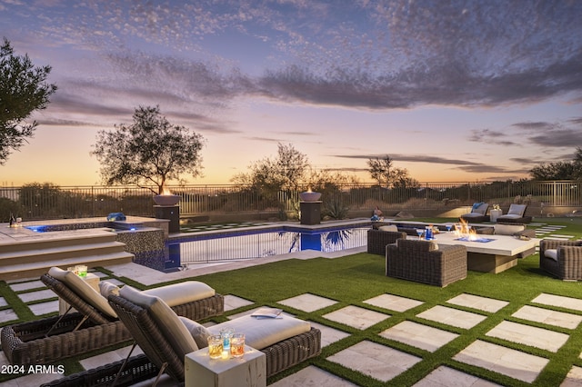 pool at dusk with a yard, a patio, and an outdoor living space with a fire pit