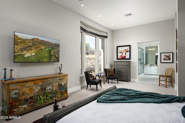 bedroom with connected bathroom and light colored carpet