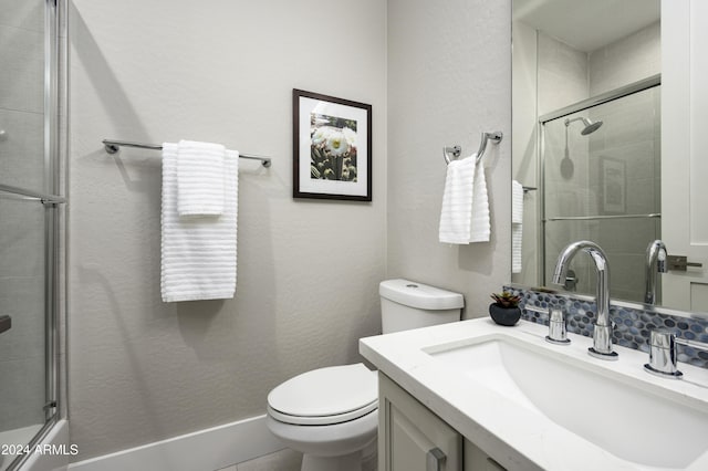 bathroom featuring vanity, toilet, and an enclosed shower