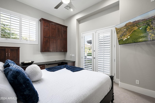 bedroom featuring multiple windows, access to outside, light colored carpet, and ceiling fan