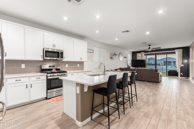 kitchen featuring light wood-type flooring, an island with sink, sink, and stainless steel appliances