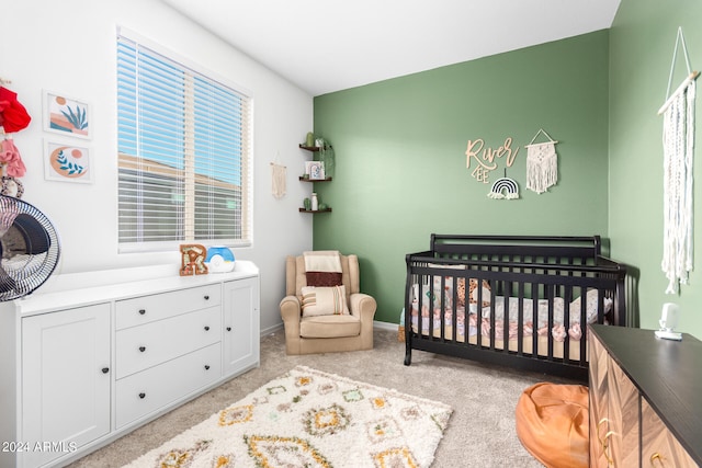 carpeted bedroom with a nursery area