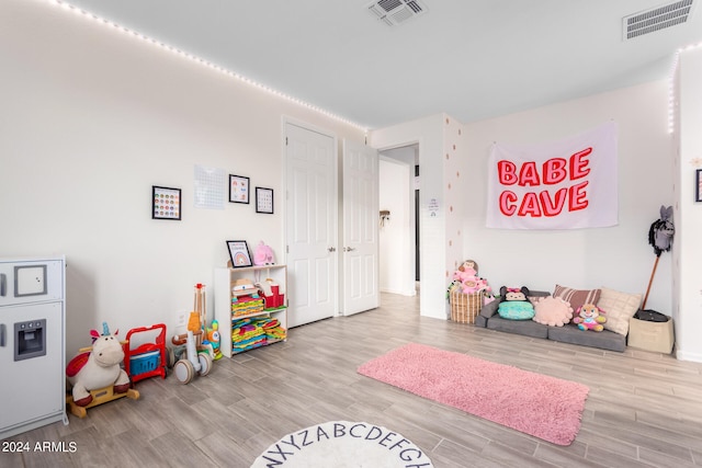 game room with light hardwood / wood-style flooring