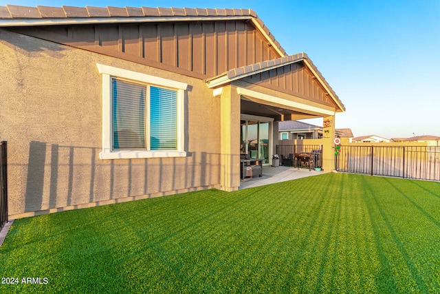 rear view of property with a yard and a patio