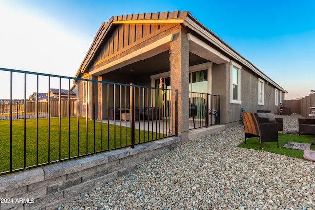 back of house featuring a lawn, outdoor lounge area, and a patio area