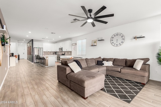 living room featuring light hardwood / wood-style floors and ceiling fan