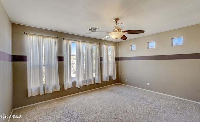 carpeted spare room with ceiling fan