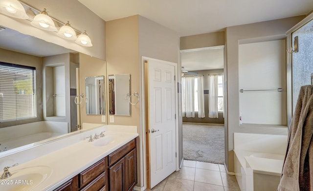 bathroom featuring tile patterned flooring, vanity, and a bath