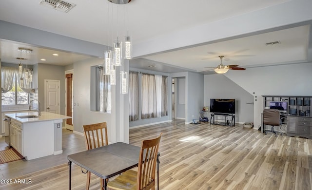 dining space with ceiling fan, sink, and light wood-type flooring